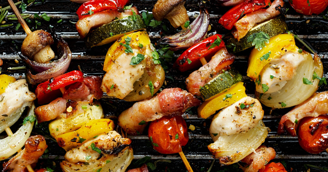 Grilled vegetable and meat skewers in a herb marinade on a grill