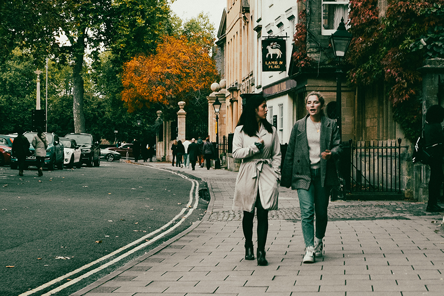 two women walking down street in conversation