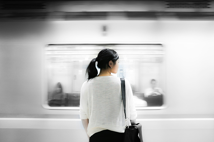 woman in front of moving subway train