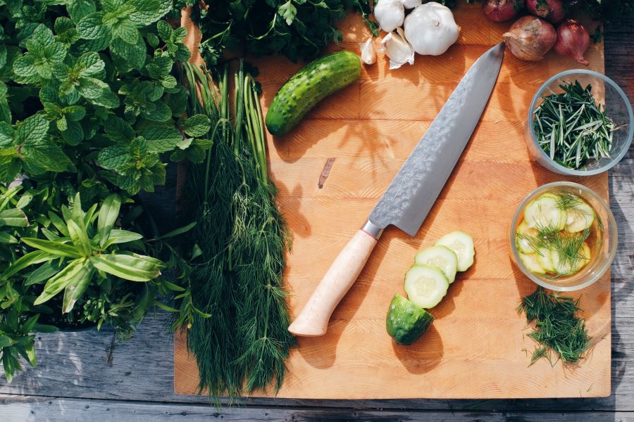 knife on cutting board with greens