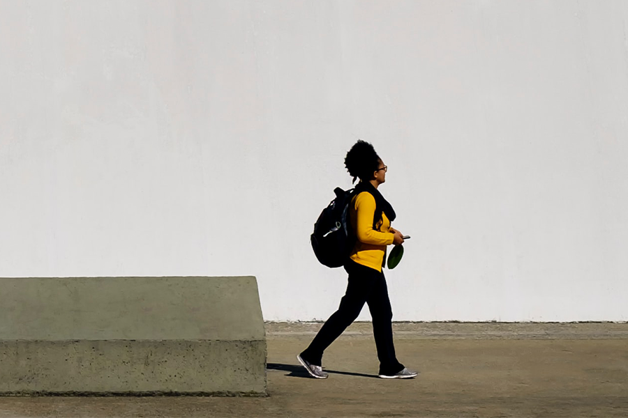 woman walking against plain background