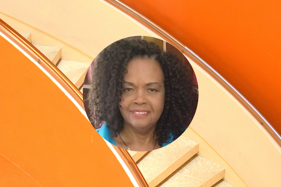 Brenda Kahari headshot on orage staircase