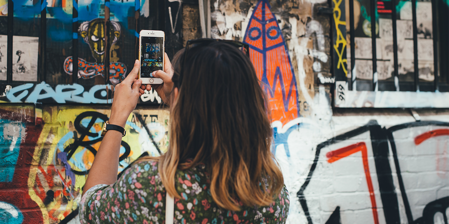 woman taking a photo of graffiti