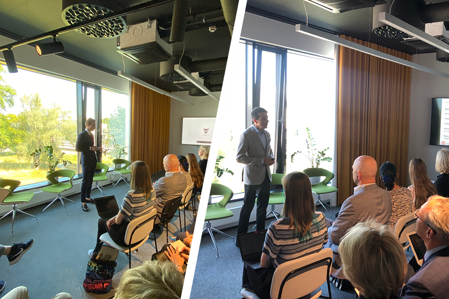 Young practitioners listening to speakers from a panel in a conference room in Estonia