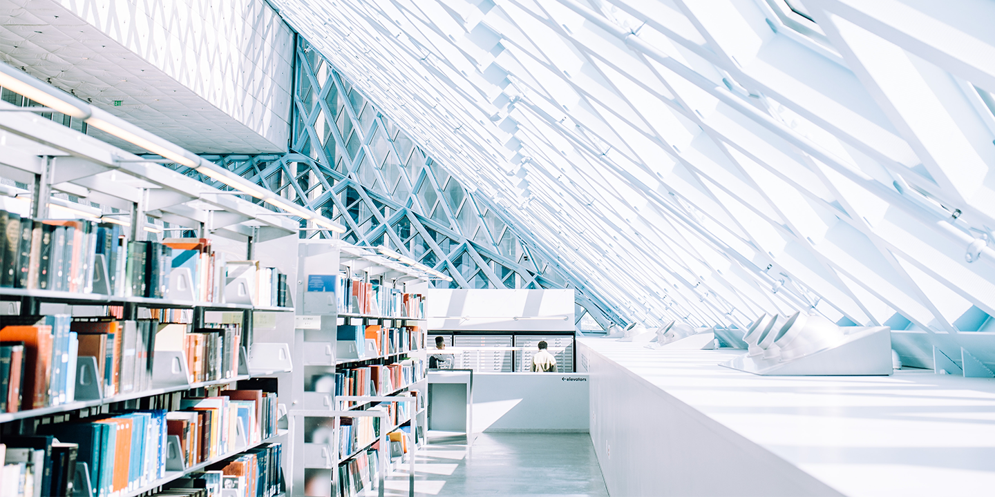 bookshelves under a bright geometric skylight